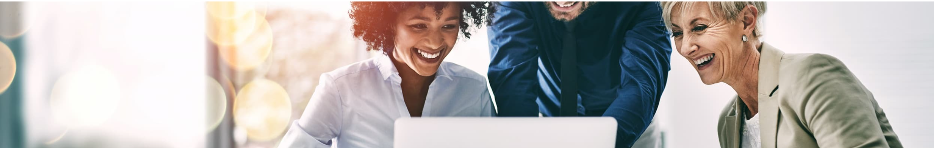 Team smiling and working together on a laptop